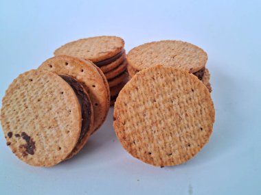 Nefis sandviç bisküvileri, kremalı çikolata dolgulu, mükemmel istiflenmiş ve tatlı bir atıştırmalık için hazır, beyaz bir arka plan izole edilmiş.