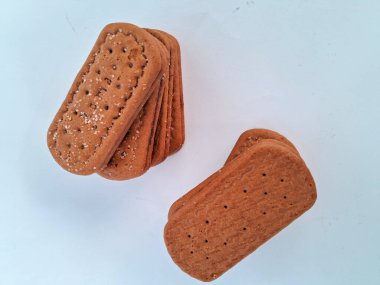 Narin bir dokuya sahip altın kahverengi bisküviler, bir fincan çayla veya lezzetli bir aperatifle eğlenmek için mükemmel, beyaz bir arka plan izole edilmiş.