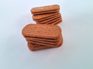 Narin bir dokuya sahip altın kahverengi bisküviler, bir fincan çayla veya lezzetli bir aperatifle eğlenmek için mükemmel, beyaz bir arka plan izole edilmiş.