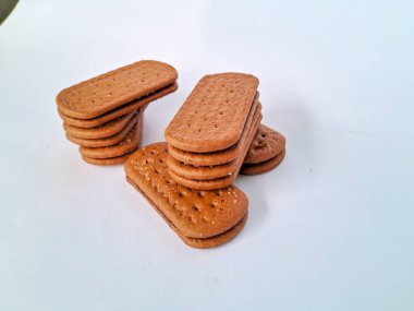 Narin bir dokuya sahip altın kahverengi bisküviler, bir fincan çayla veya lezzetli bir aperatifle eğlenmek için mükemmel, beyaz bir arka plan izole edilmiş.