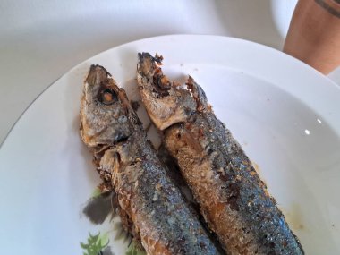 Beyaz bir kasede kızarmış uskumru balığı, beyaz bir arkaplan.