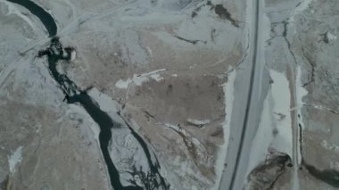 İzlanda 'da kışın donmuş yol ve dağ ıssız ve çorak bir arazi 4K' da. Yüksek kalite 4k görüntü