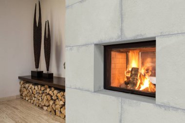 İçi gri deri mobilya seti, taş şömine ve televizyon, ahşap kitap rafı, beyaz kahve masası, renkli mermer duvar ve zemin, gri seramik kapta taze bitki. 3B Hazırlama