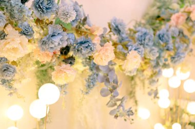 Düğün ve nişan etkinlikleri için çiçek süslemesi. Sentetik çiçekler dekorun bir parçası. Yapay çiçek ve taze çiçek süslemesi. Yuvarlak ışıkları olan düğün arkaplanı