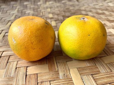 Örülmüş bambu arkaplanlı portakalları kapat