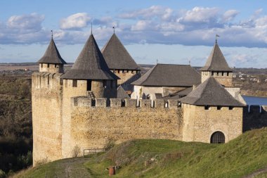 Khotyn fortress on the banks of the Dniester River in Ukraine in warm autumn. Cloudy sky at the fortress. Beautiful landscape with a fortress. clipart