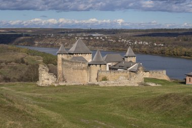 Khotyn fortress on the banks of the Dniester River in Ukraine in warm autumn. Cloudy sky at the fortress. Beautiful landscape with a fortress. clipart