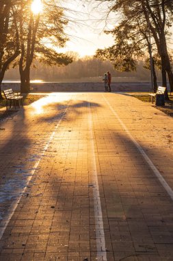 Akşamları güzel bir sonbahar parkı. Parktaki kaldırım taşı yolu sete çıkıyor..