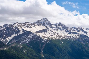 Alplerdeki güzel dağ manzarası. Bulutlu gökyüzü ile resimli dağ manzarası.