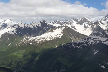 Alplerdeki güzel dağ manzarası. Bulutlu gökyüzü ile resimli dağ manzarası.