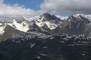 Alplerdeki güzel dağ manzarası. Bulutlu gökyüzü ile resimli dağ manzarası.