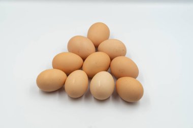 Beyaz bir yüzeyde, gölgeli bir sırayla yumurtaların yakın plan çekimi.