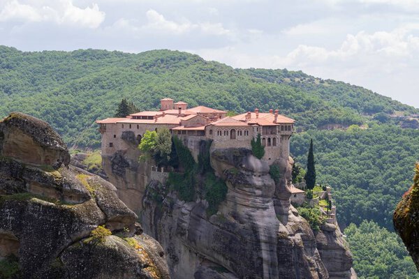Метеорные монастыри на вершине горы в утреннем тумане в Греции Каламбака.