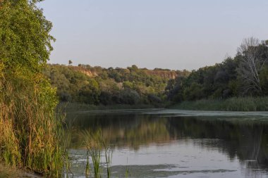 Şafakta nehir ve ormanın olduğu güzel sonbahar manzarası.