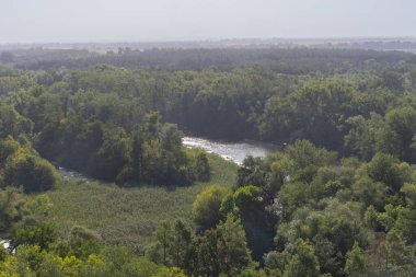 Tepenin tepesinden nehrin güzel manzarası. Bir sonbahar sabahı bir nehir ve dik bir kıyıya sahip bir manzara..