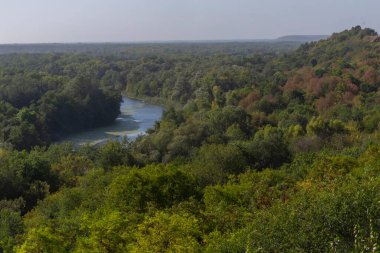 Tepenin tepesinden nehrin güzel manzarası. Bir sonbahar sabahı bir nehir ve dik bir kıyıya sahip bir manzara..