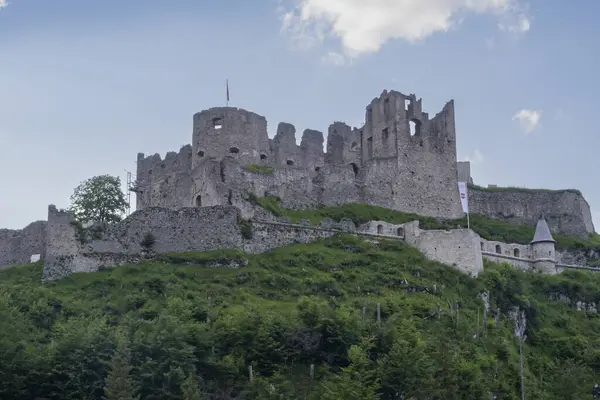 Avusturya Alpleri 'ndeki bir dağın tepesindeki harap olmuş bir ortaçağ şatosunun manzarası. Şatosu olan bir dağ manzarası.