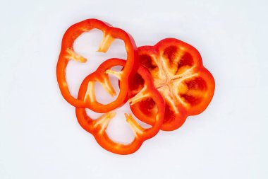 Taze ve sulu kırmızı biber beyaz arka planda halka şeklinde kesilmiş. Sağlıklı beslenme konsepti, doğal gıdalar, diyet ve kilo kaybı.