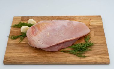 Tahta üzerinde taze çiğ tavuk göğsü, dereotu ve sarımsaklı..