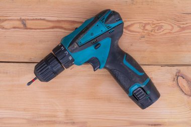 Tahta bir yüzeye elektrikli tornavida ve matkap. Marangozun tahtayla çalışma aracı.