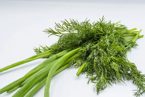 Taze yeşil soğan ve beyaz arka planda dereotu. Sağlıklı yemek.