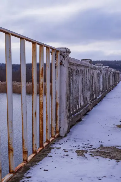 Nehrin üzerindeki köprünün rayları. Köprünün mimari unsurları. Nehrin üzerinden geçen yayalar..