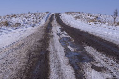 Toprak yol kışın pahalıdır. Bir yolu olan kış manzarası.
