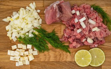 Ahşap arka planda dereotlu, limonlu ve sebzeli taze çiğ et. Yakın plan.