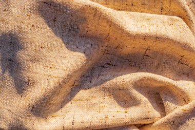 doku arkaplanı. Doğal kumaş dokusu, kahverengi keten, yüzeyde özgürce yatıyor. Keten kumaş doğal katlar oluşturur, tasarım için arkaplan.