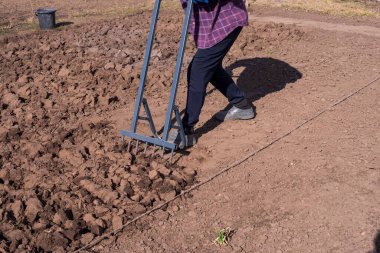 Bahçede kürekle tarlada çalışan bir çiftçi.