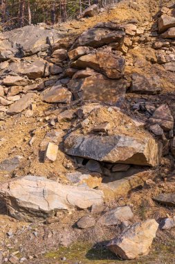 Granit ocağının kayalık uçurumunun manzarası. Büyük taşlar. Taş katmanlar.