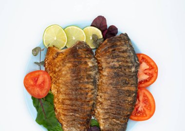 Domatesli ve limonlu kızarmış balık. Beyaz arka planda ızgara balık..