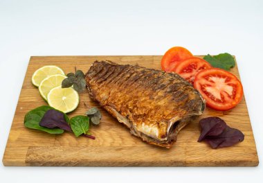 Ahşap bir tahtada kızarmış sazan balığı servis ettim. Domatesli, limonlu ve otlu kızarmış balık.