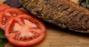 Ahşap bir tahtada kızarmış sazan balığı servis ettim. Domatesli, limonlu ve otlu kızarmış balık.