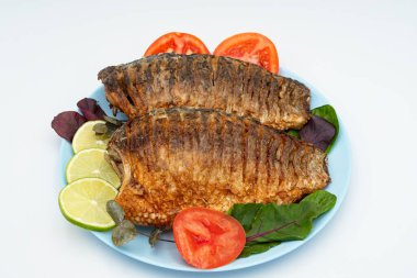 Domatesli ve limonlu kızarmış balık. Beyaz arka planda ızgara balık..