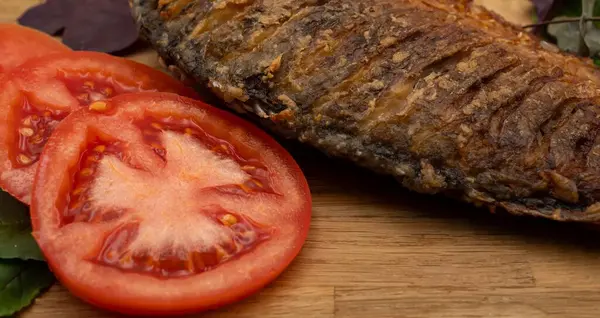 Ahşap bir tahtada kızarmış sazan balığı servis ettim. Domatesli, limonlu ve otlu kızarmış balık.
