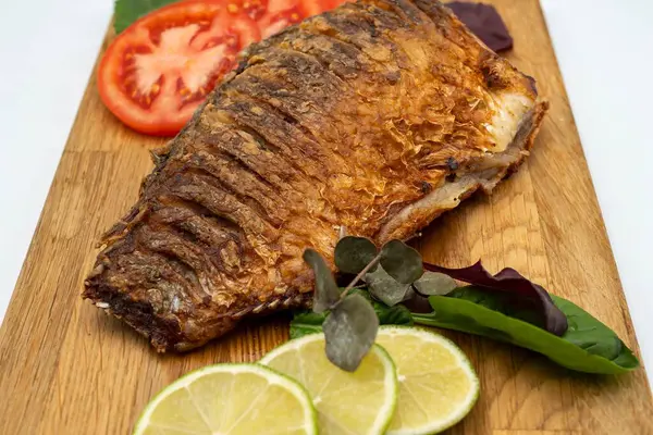 Ahşap bir tahtada kızarmış sazan balığı servis ettim. Domatesli, limonlu ve otlu kızarmış balık.