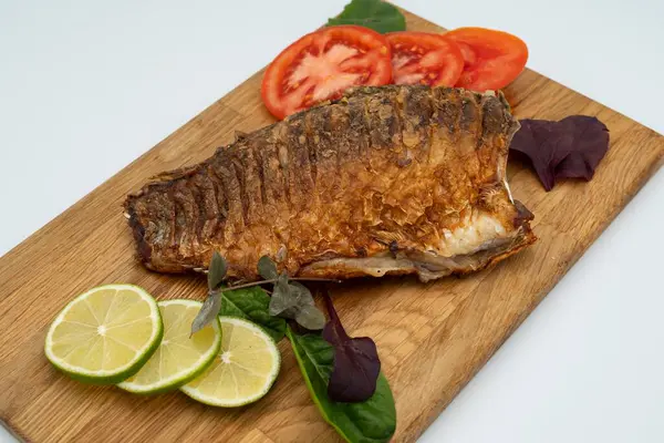 Ahşap bir tahtada kızarmış sazan balığı servis ettim. Domatesli, limonlu ve otlu kızarmış balık.