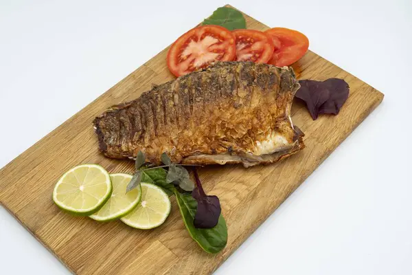 Ahşap bir tahtada kızarmış sazan balığı servis ettim. Domatesli, limonlu ve otlu kızarmış balık.