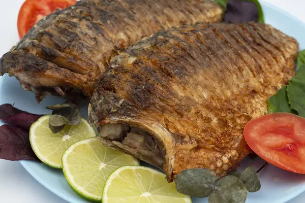 Domatesli ve limonlu kızarmış balık. Beyaz arka planda ızgara balık..