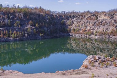 Terk edilmiş granit ocağı, bir göl ve kayalık bir sahil. Güzel manzara. Doğal manzara..