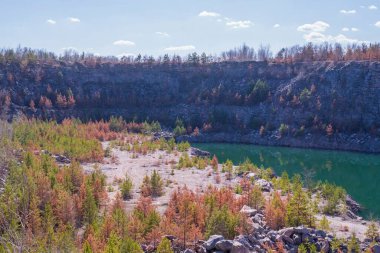 Terk edilmiş granit ocağı, bir göl ve kayalık bir sahil. Güzel manzara. Doğal manzara..
