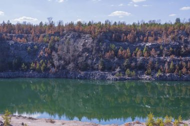 Terk edilmiş granit ocağı, bir göl ve kayalık bir sahil. Güzel manzara. Doğal manzara..