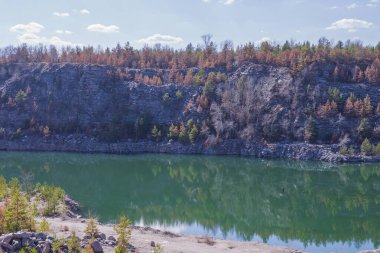 Terk edilmiş granit ocağı, bir göl ve kayalık bir sahil. Güzel manzara. Doğal manzara..