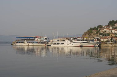 Gündoğumunda Ohri Gölü 'nde eğlence ve balıkçı tekneleri.