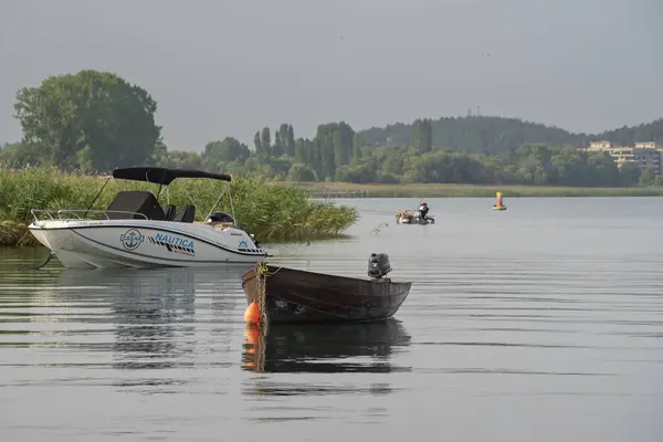 Gündoğumunda Ohri Gölü 'nde eğlence ve balıkçı tekneleri.