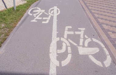 Sokakta bisiklet yolu var. Şehirdeki asfalta uygulanan bisikletçiler için yol işareti.