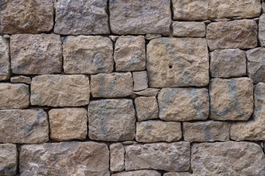 Düz olmayan taş bloklardan yapılmış eski taş duvar. İşlenmiş kaba taşın dokusu.