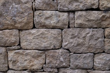 Düz olmayan taş bloklardan yapılmış eski taş duvar. İşlenmiş kaba taşın dokusu.