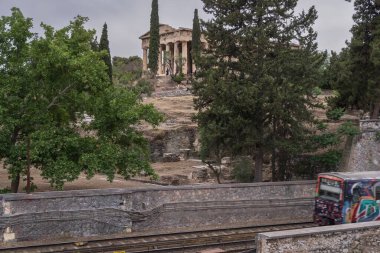 Yunanistan 'ın Monastyraki bölgesindeki Atina' daki antik Akropolis kentinden bir metro treni geçiyor. Atina, 23 Mayıs 2025